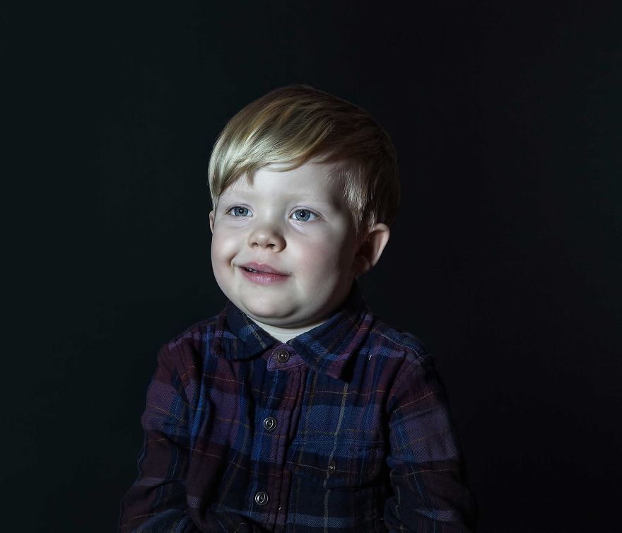 Portrait of a boy in plaid shirt vacantly staring. He is engrossed in TV.